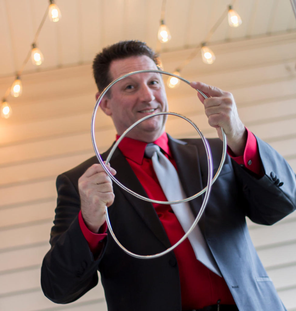 Ben Ulin comedian magician performing linking ring trick at house concert